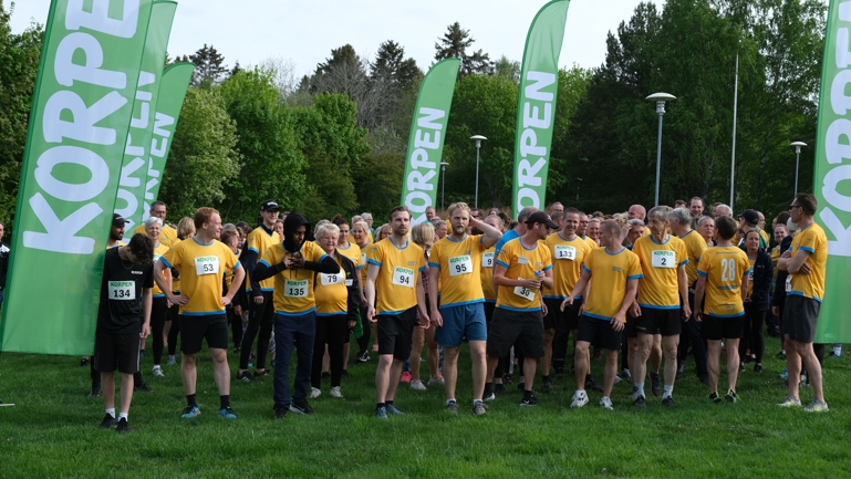 En samling människor iklädda Motionslandslagets tröjor väntar på att springa ett lopp.