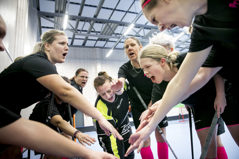 Spelare har samlats i en ring inför en innebandymatch.